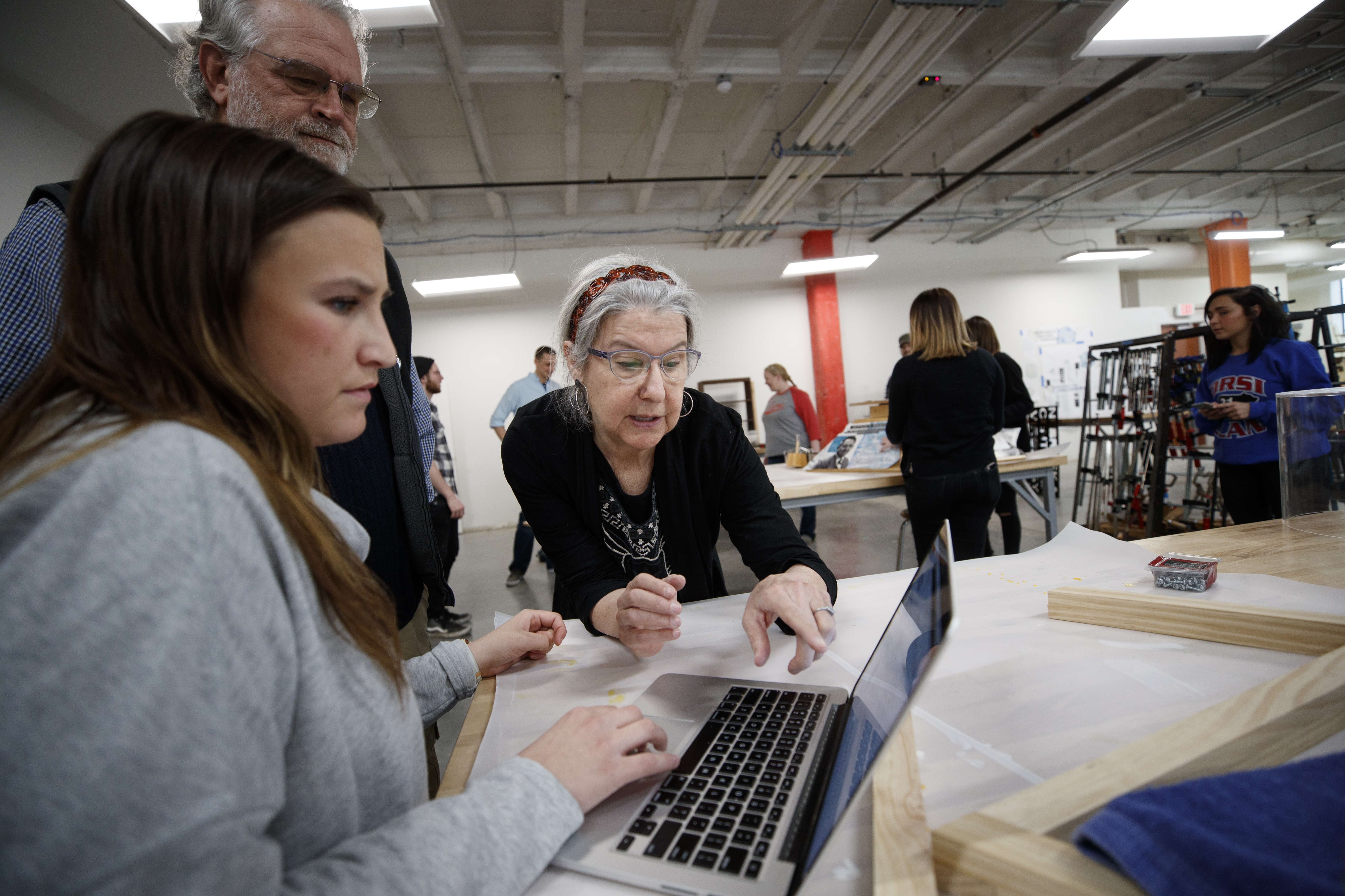 Photo of Librarian Judy Diamond assisting a student on a laptop