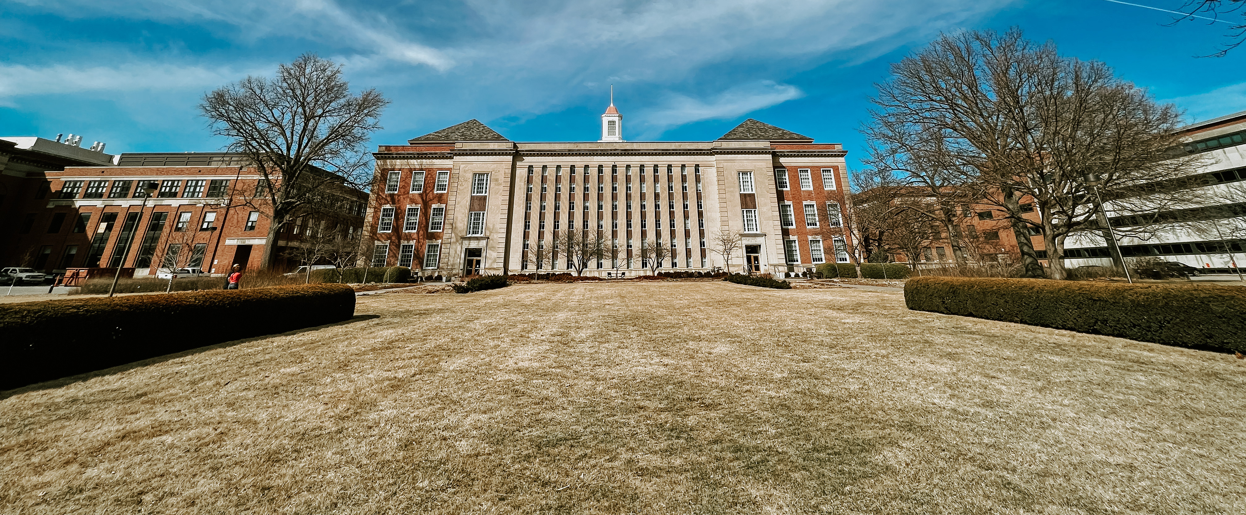 Photo of Love Library South exterior with blue sky and clouds