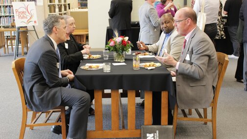Attendees eating appetizers at a table