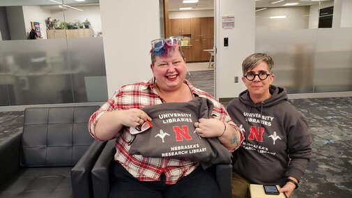 Student with Libraries hoodie presented by Scout Calvert, Research Partnerships Librarian