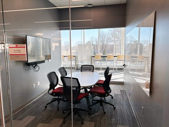table with 6 chairs, wall monitor and whiteboard
