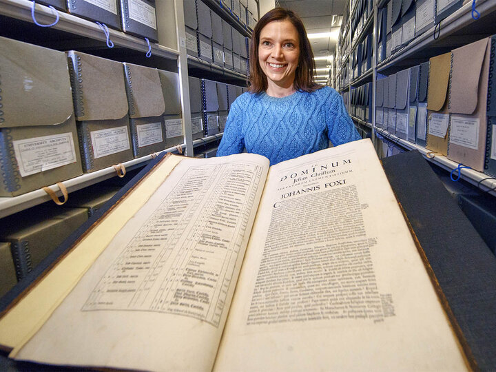 Traci Robison, photo and exhibits specialist with Archives and Special Collections in University Libraries, displays a volume of John Foxe's "Book of Martyrs."