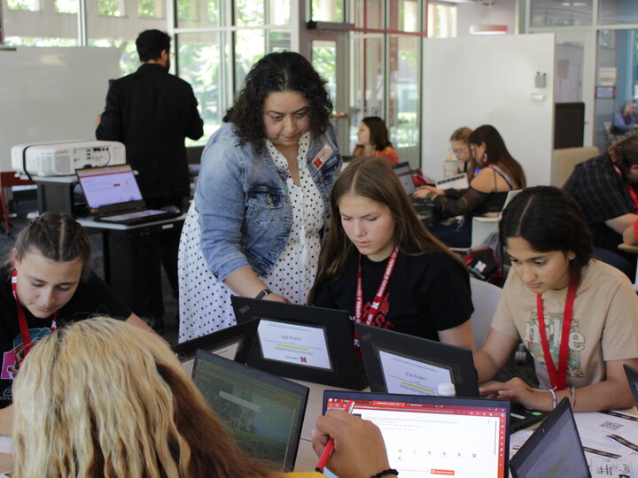 Librarians assisting students using laptops