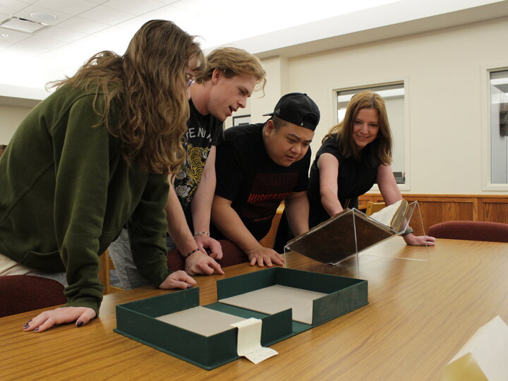 Librarian Traci Robison assisting students with materials in the reading room.