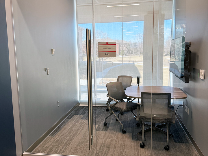 table with 3 chairs and wall monitor