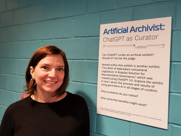 Photo of staff member standing next to a poster describing the exhibit