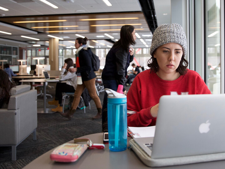 student at table with laptop studying