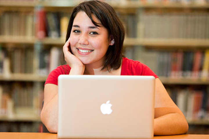 Photo of student with laptop in the Library