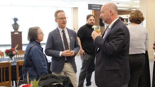 One woman and two men talking 