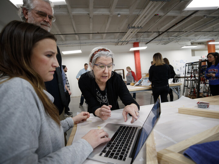 Librarian and student looking at laptop screen