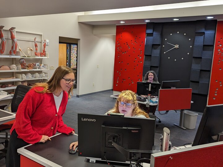 Student at an askus desk looking at computer with an askus associate